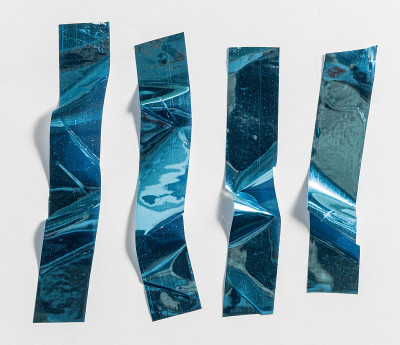 闪亮的皱巴巴的贴纸。很酷的金属全息胶带形状孤立在白色背景上。