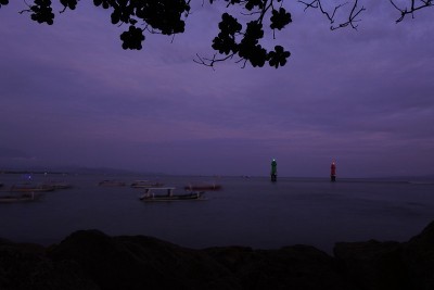 日落前的下午在海滩上。海滩上不知名人物的剪影。巴厘岛是迷人的海滩天堂。
