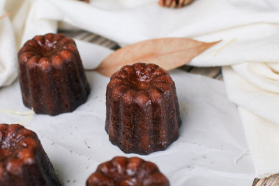 波尔多Caneles -传统的法国甜甜点与茶或咖啡在木制背景。