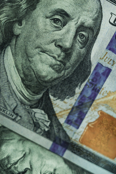把富兰克林的脸凑近放在一百美元上。美元，现金，货币背景。