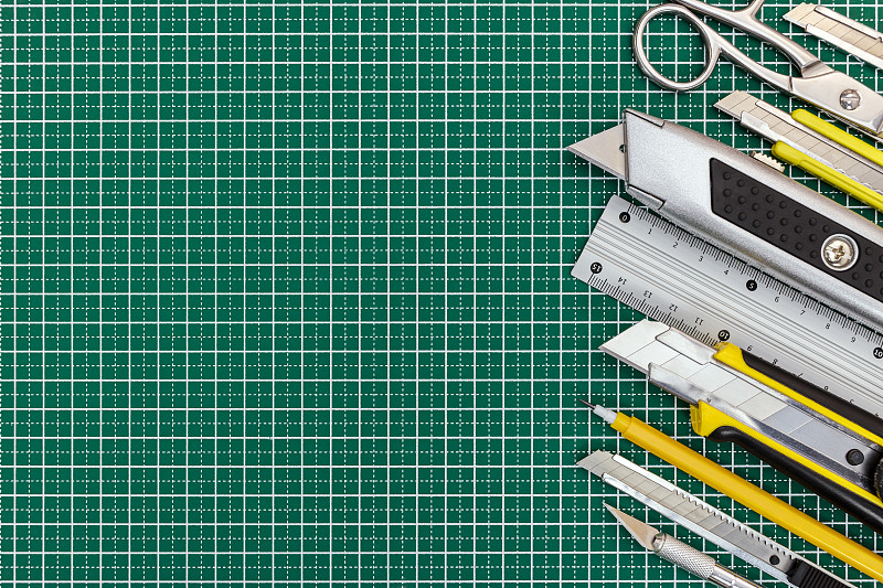 学校工具和办公用品上的绿色切割垫为背景