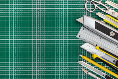 学校工具和办公用品上的绿色切割垫为背景