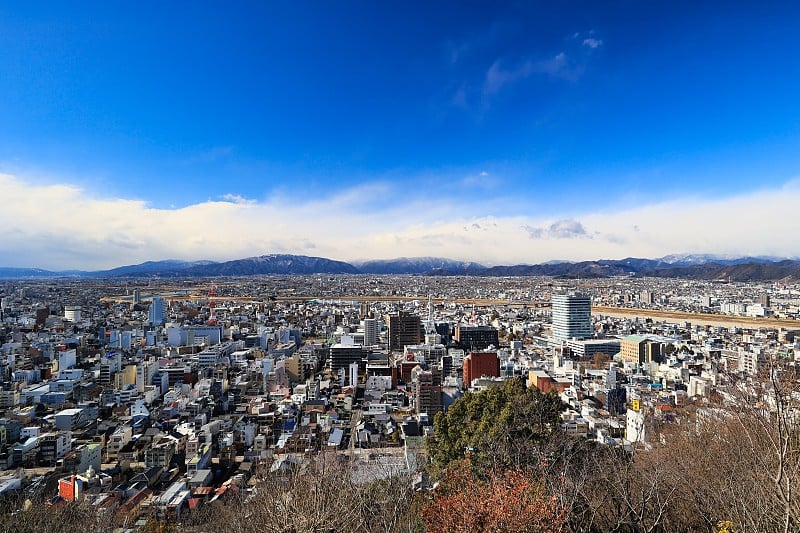 阳光明媚的一天，从岐阜县岐阜市的一座山上俯瞰的城市景观