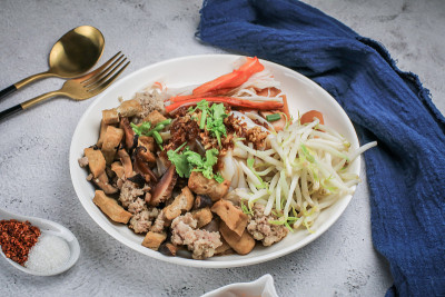 中国蒸米粉猪肉，香肠，仿蟹肉棒，煮豆芽，蘑菇和豆腐在甜酱油在白色盘子。桌上放辣椒粉、泡辣椒和糖。