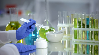 生物化学家从试管中提取乳霜样本，有机美容产品，皮肤病学