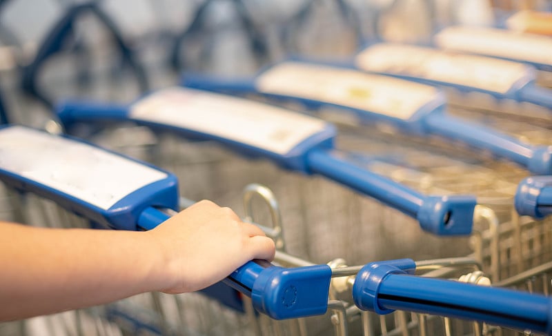 The female hand pushing the trolley cart shopping 