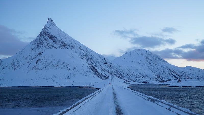 挪威罗浮敦市弗雷德旺的冬季冷雪景观，日落时占主导地位的沃兰斯坦德峰。