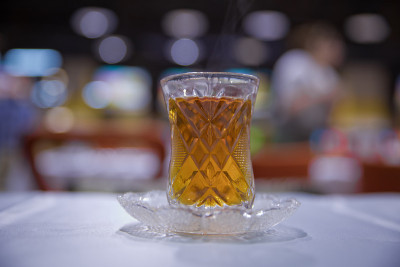 阿塞拜疆传统armudu茶梨形玻璃杯。阿塞拜疆红茶与复古的白色桌子。土耳其黑茶梨形杯，阿塞拜疆传统芳