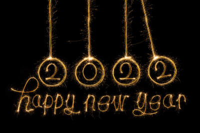 2022年新年快乐。闪闪发光的燃烧文本Happy New Year 2022孤立在黑色背景。美丽的发