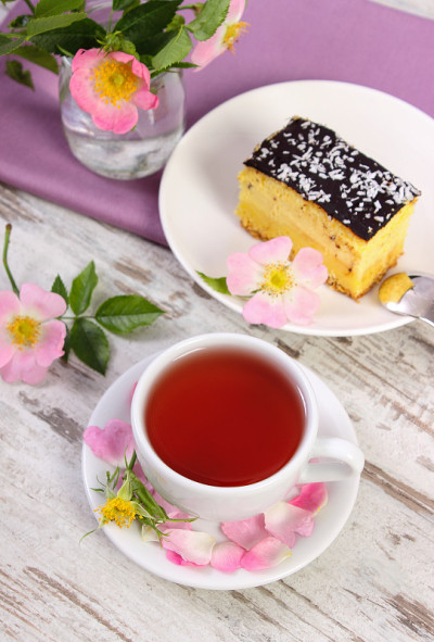 一杯有芝士蛋糕和野玫瑰的茶