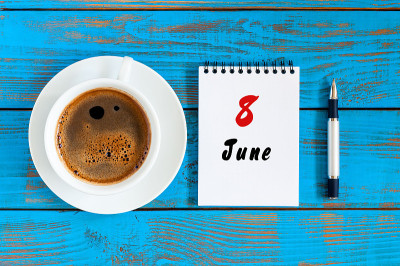 6月8日。图片6月8日，每日日历上的蓝色背景与早上的咖啡杯。夏日，俯视图