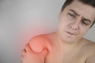 一个男人正在忍受肩膀疼痛。肩伤、肌腱炎、扭伤或肌腱炎症。急性疼痛和身体不同部位炎症的概念