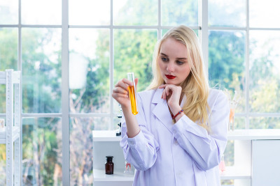 一个女性研究人员在化学实验室里进行研究的科学家拿着试管和样品在实验室分析的背景