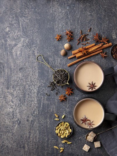 Indian masala tea with milk and spices in mug. Gre