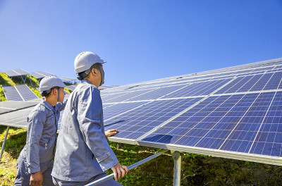 两名亚洲工人在烈日下检查山上的太阳能光伏