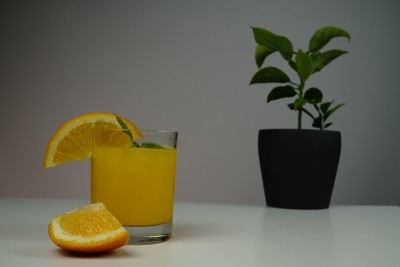 白色的桌子上放着一杯新鲜的橙汁