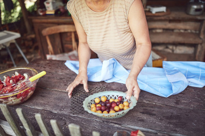 女人准备食物和盛宴的夏季午餐在农村乡村别墅户外厨房。