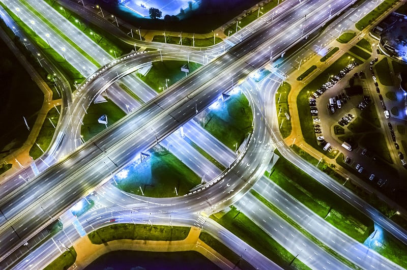 从无人机鸟瞰现代多层次道路交叉口和回旋处的夜晚