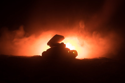 火箭发射与火云。火箭导弹和弹头瞄准夜晚灰暗的天空的战斗场景。《战争背景》中的火箭战车