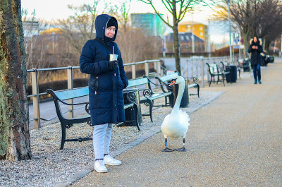 Young woman in warm winter clothes with a drink in