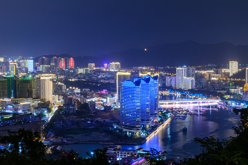 夜景三亚市与明亮的彩色照明建筑，结构，道路，人行道，杆子，桥梁。