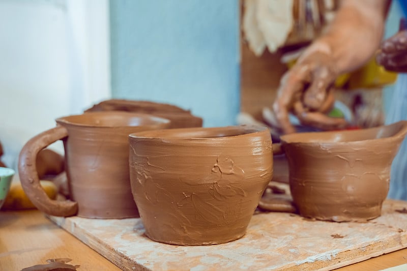 Finished raw clay cup dries on the table. Pottery 