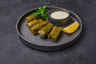 传统中东菜肴dolma或sarma，与欧芹，平底锅与酸奶油和柠檬
