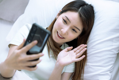 亚洲妇女视频电话给她的朋友，在线沟通的概念。