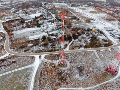 鸟瞰图电信塔的移动通信背景上的绿色田野覆盖着皑皑白雪。