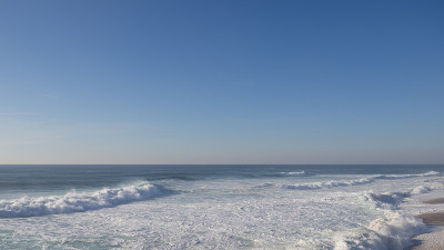 空旷的海滩和巨大的海浪在阳光灿烂的日子