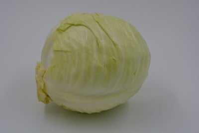 鲜亮多汁的卷心菜，一颗切下来的卷心菜头，夏天的一半乌克兰卷心菜头就坐落在白色的背景上。新鲜健康蔬菜，