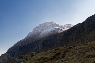 清晨的晨光映照着山，前景是湖