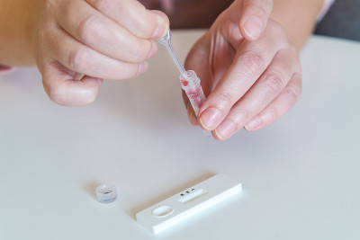 这名女子用移液管从他的手指上抽取血样