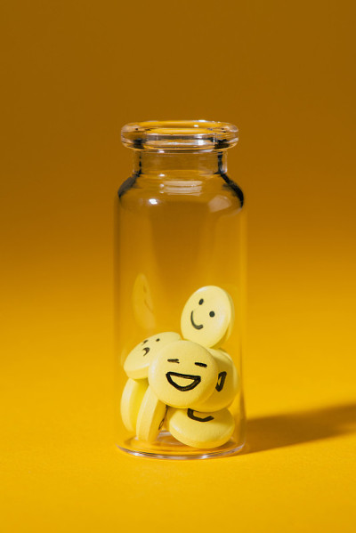 特写镜头的药丸与笑脸玻璃瓶上的黄色