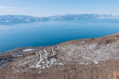 一个湖的景观在冬天与山和曲折的道路
