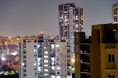 航拍古尔加翁夜晚的建筑，前面是较小的建筑，背景是摩天大楼