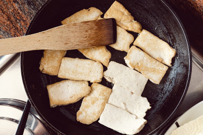 豆腐在黑色平底锅中煸炒