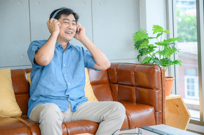 快乐、快乐、快乐、有趣的老板正在用他更新后的电脑玩游戏，通过耳机听音乐