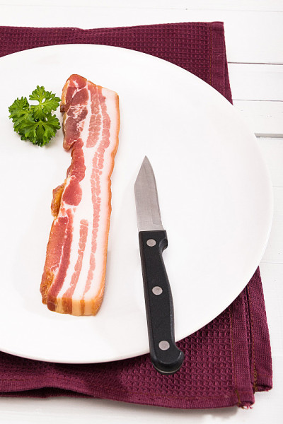 烟熏肉放在白色的盘子里