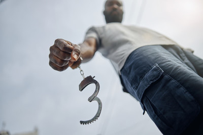 Low angle photo of international man in handcuffs
