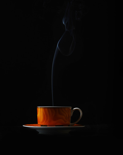 在黑色背景上热气腾腾的咖啡杯