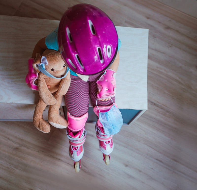 Top view of little girl wearing pink roller skates