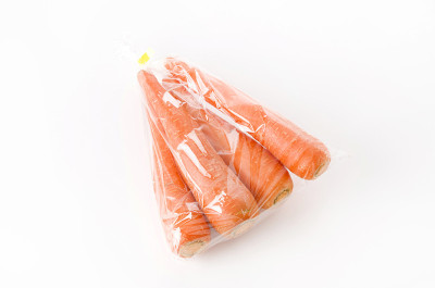 白色背景的塑料袋里的新鲜胡萝卜