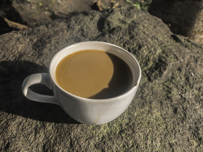 白色杯奶油咖啡孤立在石头背景