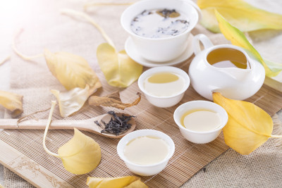 桌上放着白茶杯和秋叶。秋茶。