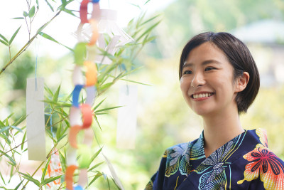 在七夕竹子上贴纸条的女人