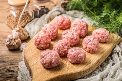 生肉丸放在木砧板上。