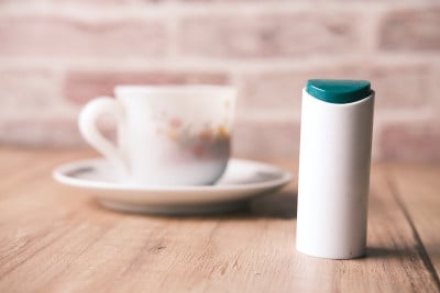 人造甜味剂容器和桌上的茶杯