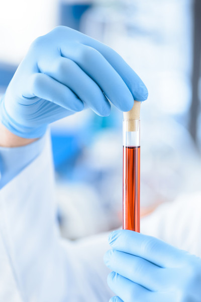 特写部分的科学家在保护手套拿着试管试剂