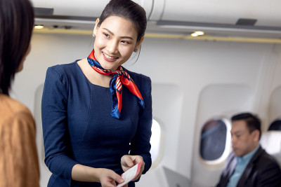 在飞机上问候乘客，空中小姐或空姐服务
